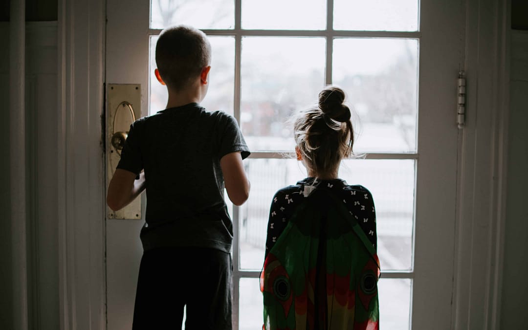 two kids looking out a window