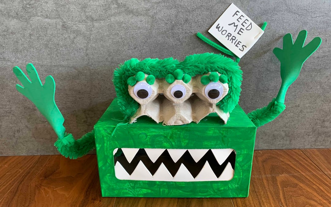A tissue box painted green made to look like a montster